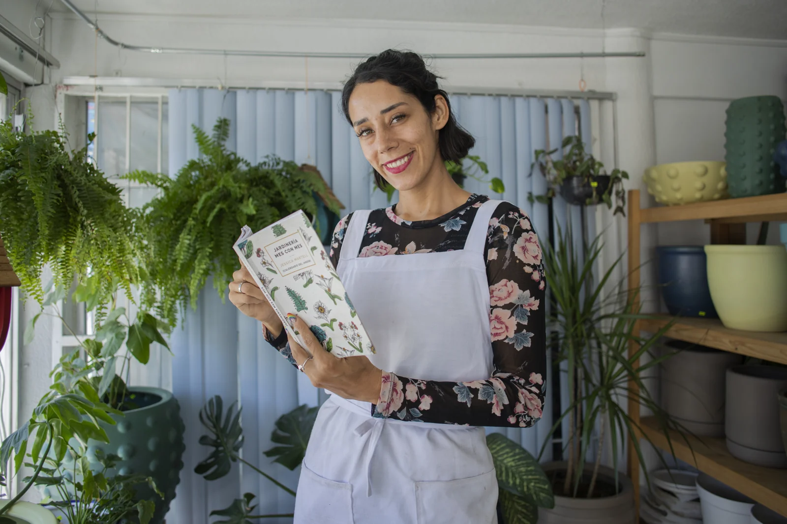 Jessica Martell en el vivero con su libro Jardinería mes con mes